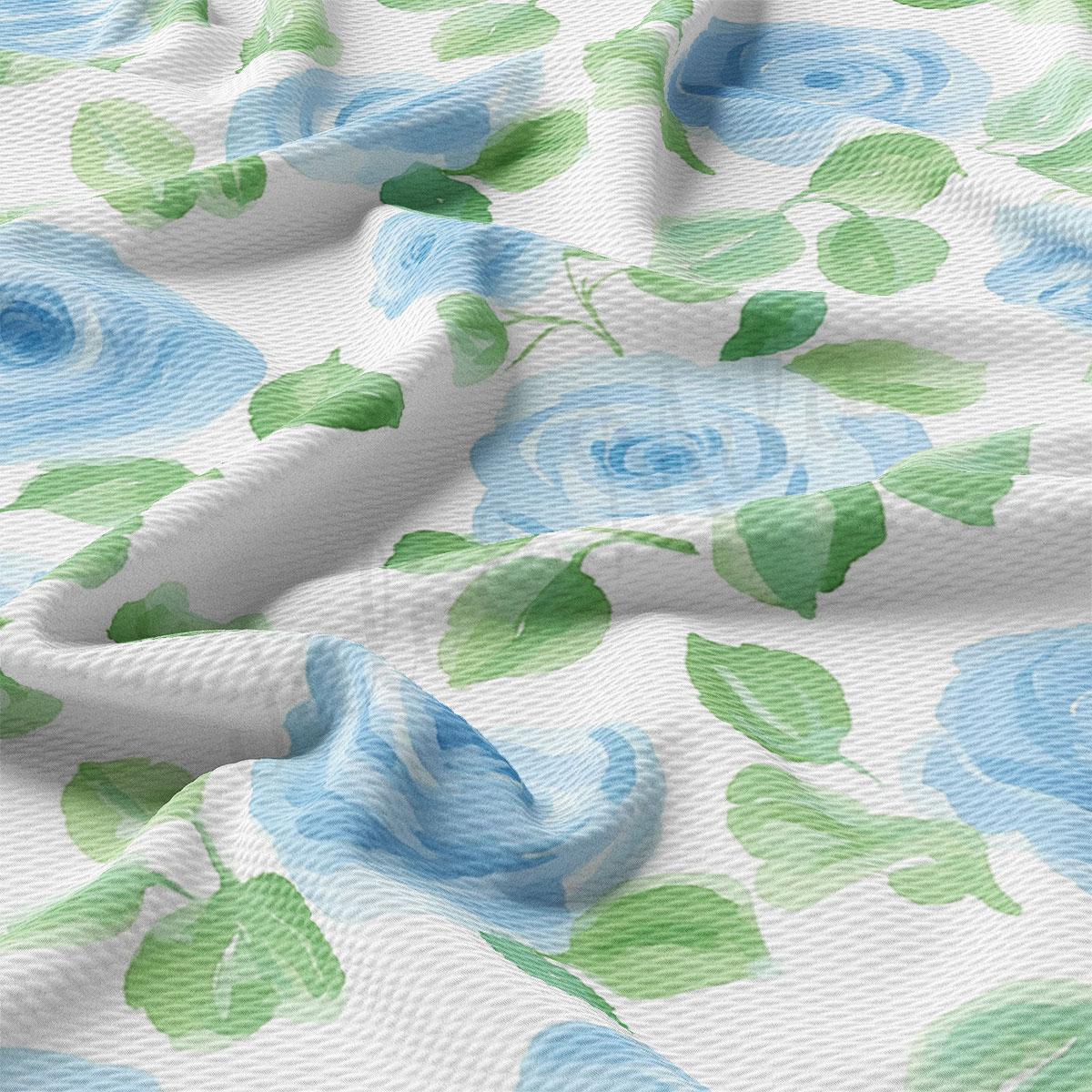 a close-up view of a fabric with a floral pattern of blue and green flowers. The fabric appears to be crumpled, giving it a soft and delicate appearance.