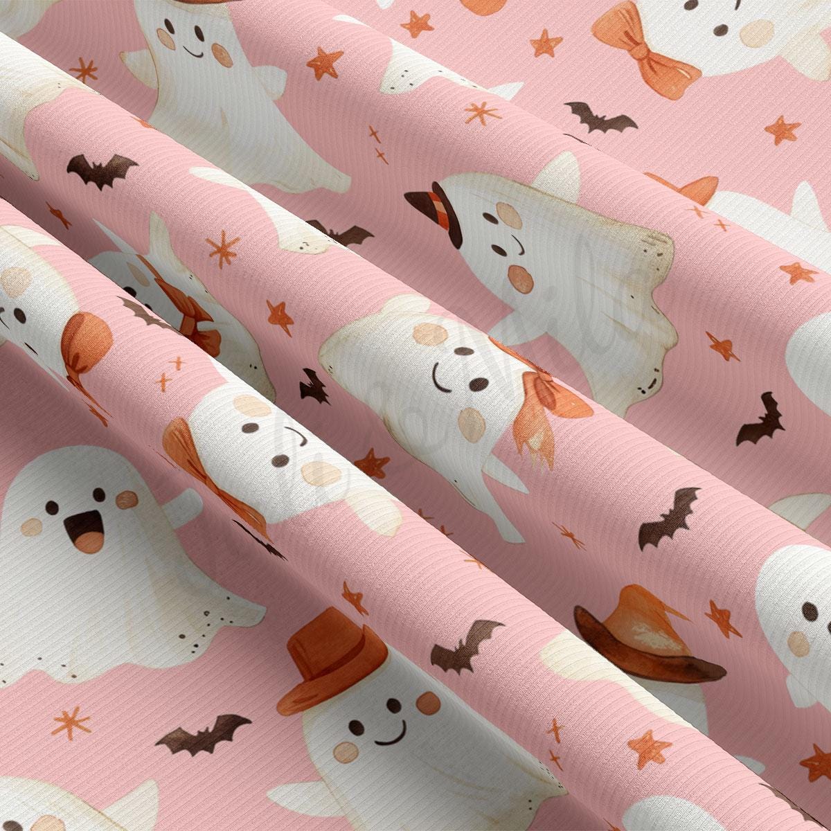 a fabric with a repeating pattern of ghost characters and bats on a pink background.