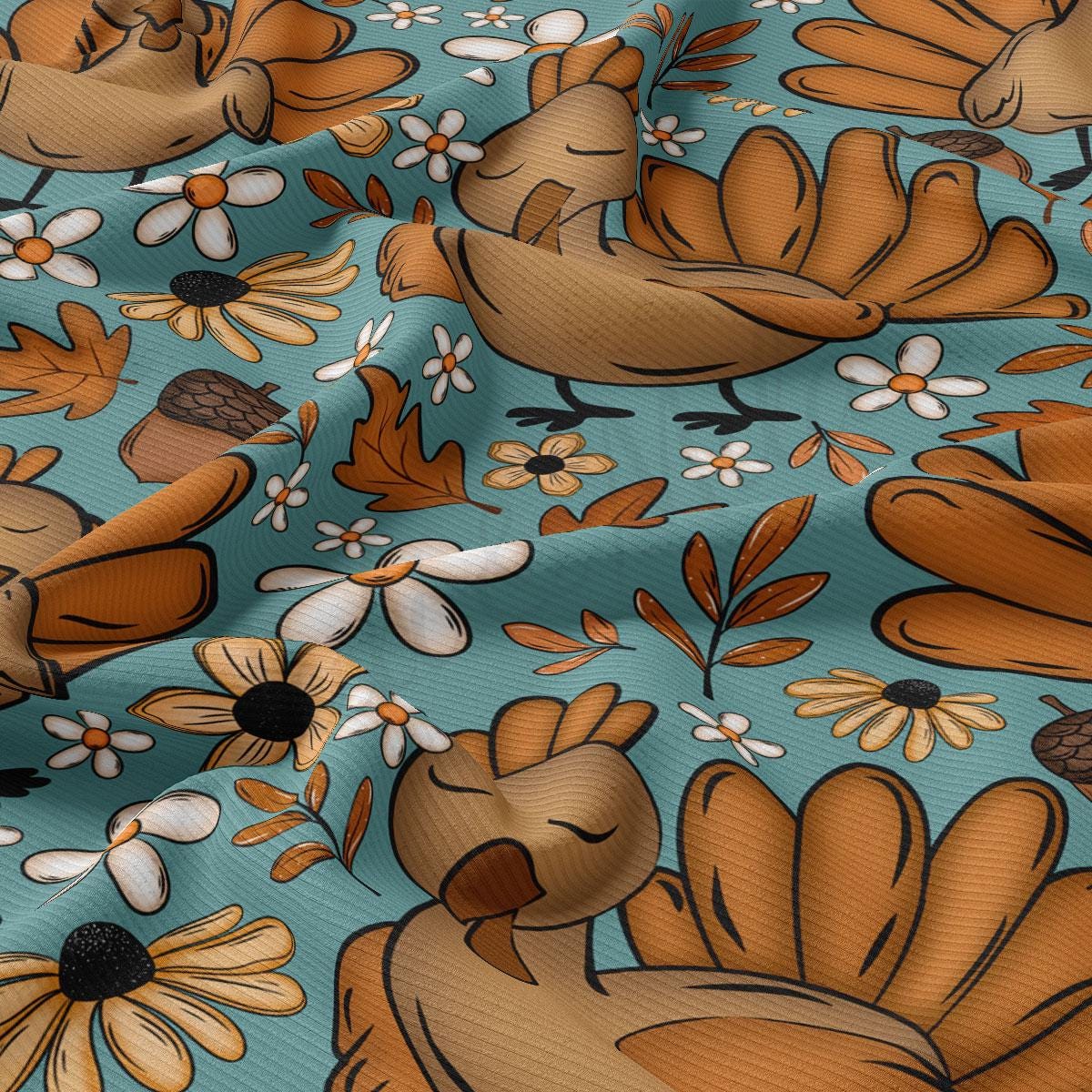 The image is a vibrant and colorful fabric with a repeating pattern of various autumn-themed elements, including birds, flowers, leaves, and acorns. The overall design is playful and whimsical, with a focus on the warm hues of orange, brown, and yellow.