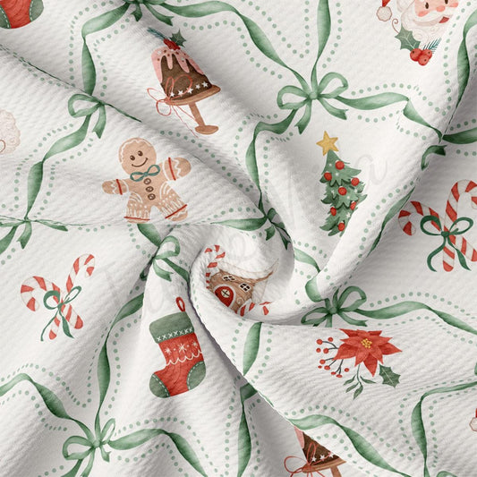 The image is a close-up of a fabric with a Christmas-themed pattern, featuring various holiday decorations such as a gingerbread man, a Christmas tree, candy canes, poinsettias, and a Santa Claus figure.