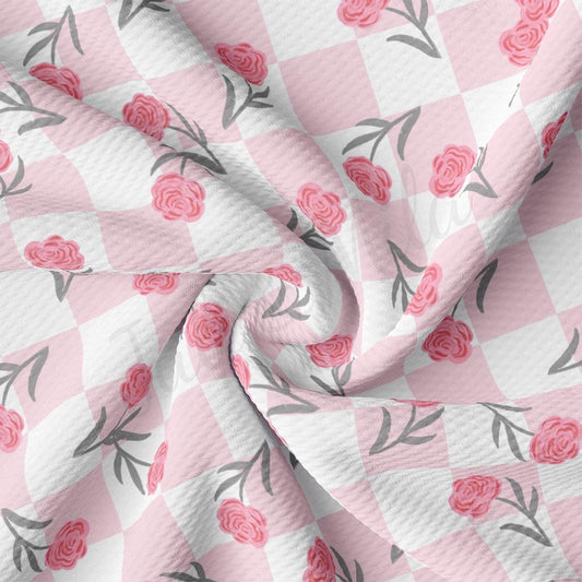 a pink and white checkered fabric with roses on it