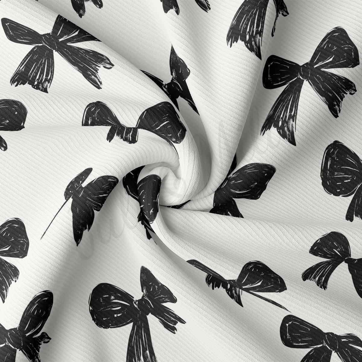 a close-up view of a fabric with a repeating pattern of black bows on a white background.