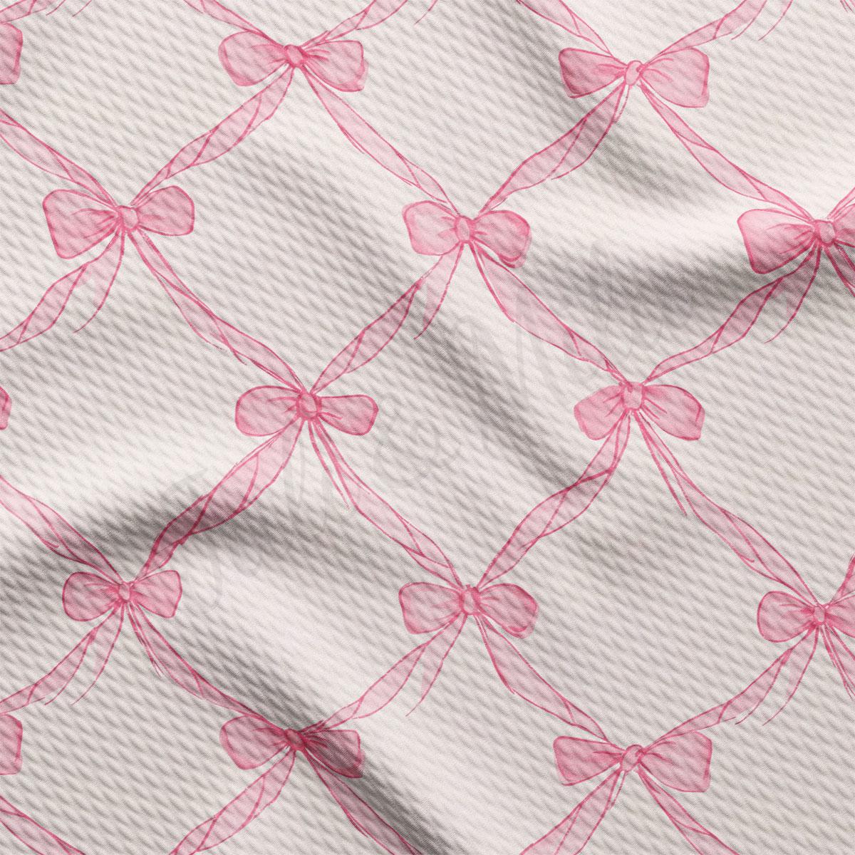 a close-up view of a fabric with a repeating pattern of pink bows on a white background.
