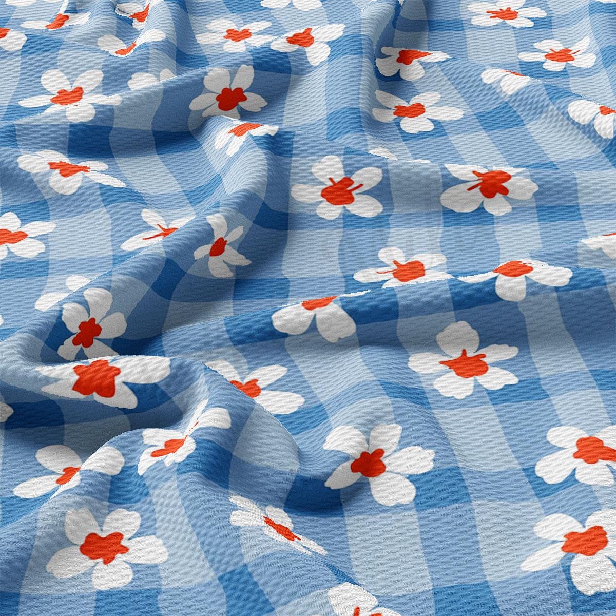 a blue and white checkered fabric with red and white flowers