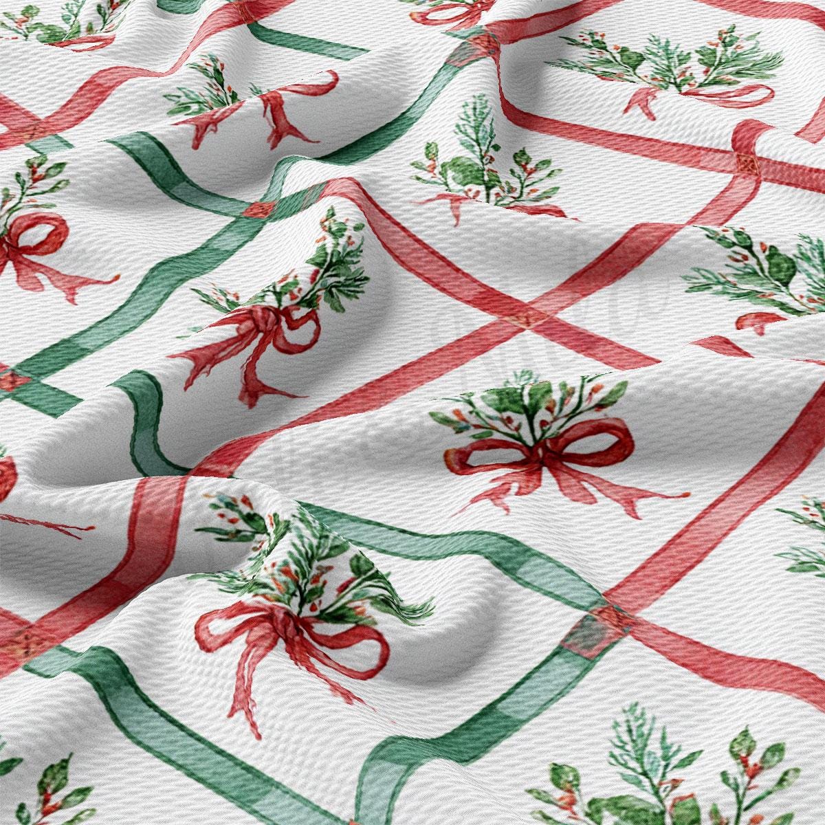 a close-up view of a fabric with a repeating pattern of red and green ribbons and leaves, creating a festive and holiday-themed design.