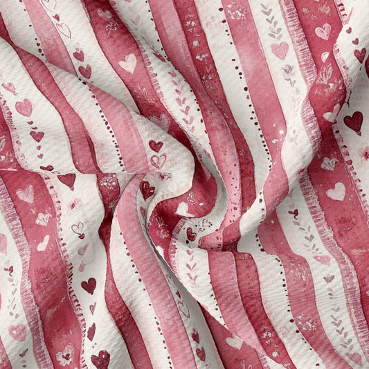 a close-up view of a fabric with a repeating pattern of pink and white stripes, along with small heart shapes scattered throughout the fabric.