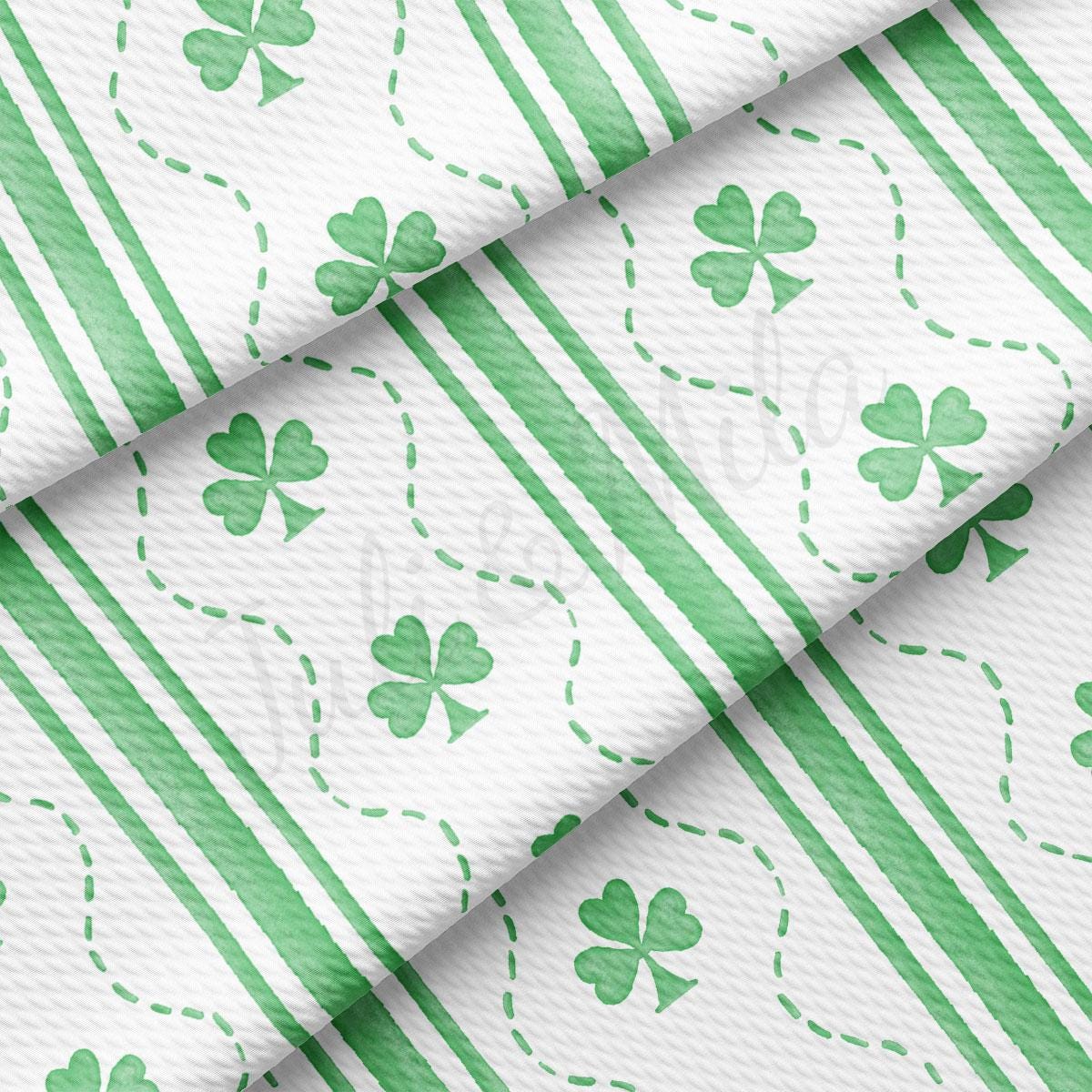 a green and white striped fabric with shamrocks on it