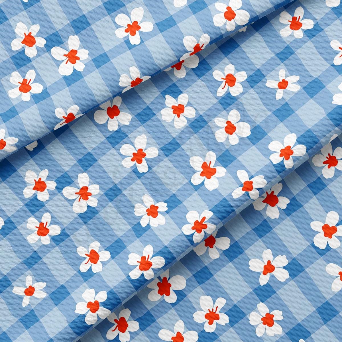 a blue and white checkered fabric with red and white flowers