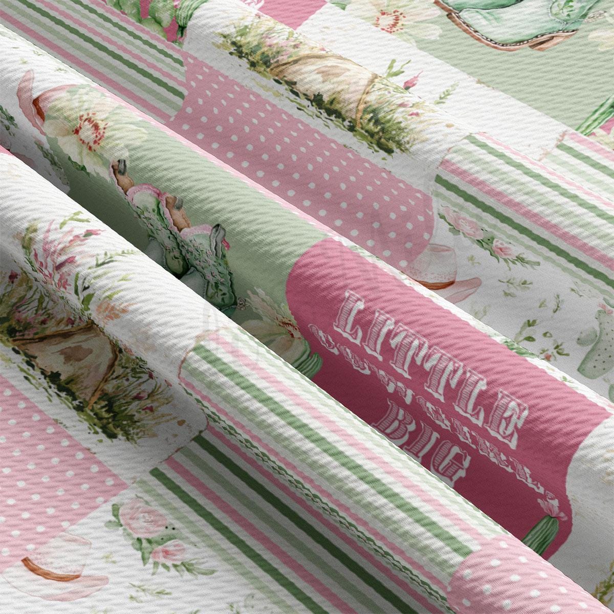 The image is a close-up of a fabric with a floral pattern, featuring a pink and green color scheme. The fabric appears to be a textile, possibly a blanket or quilt, with a repeating pattern of flowers and leaves. The text &quot;LITTLE BIG&quot; is visible on the fabric, which could be a part of a larger design or a statement made by the creator of the fabric.