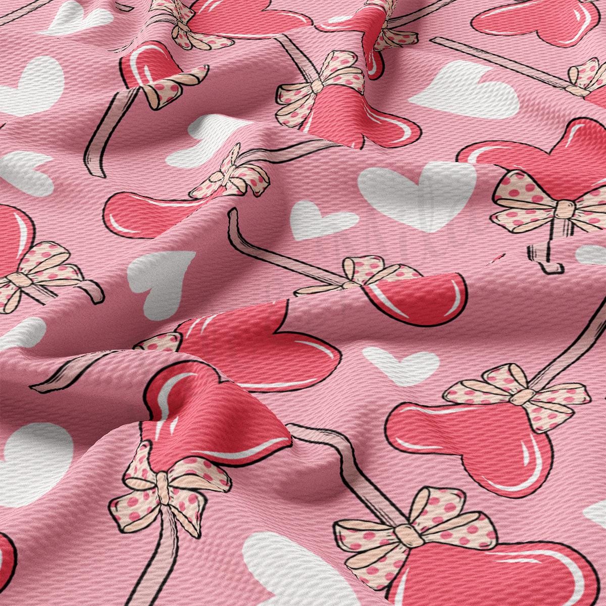 a pink fabric with hearts and bows on it