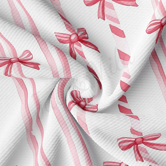 a close-up view of a fabric with a repeating pattern of pink bows on a white background.