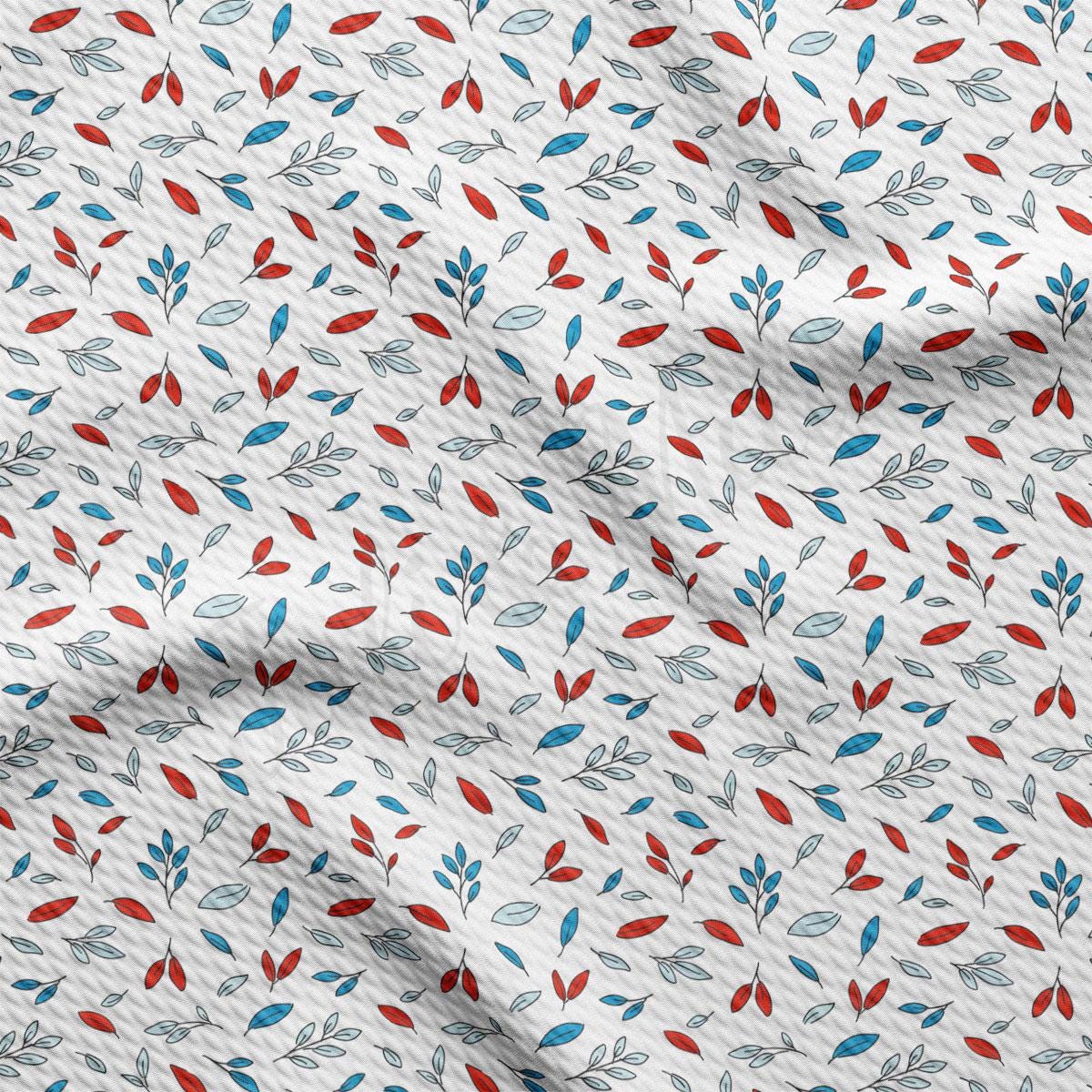 a close up of a white fabric with red, blue and green leaves