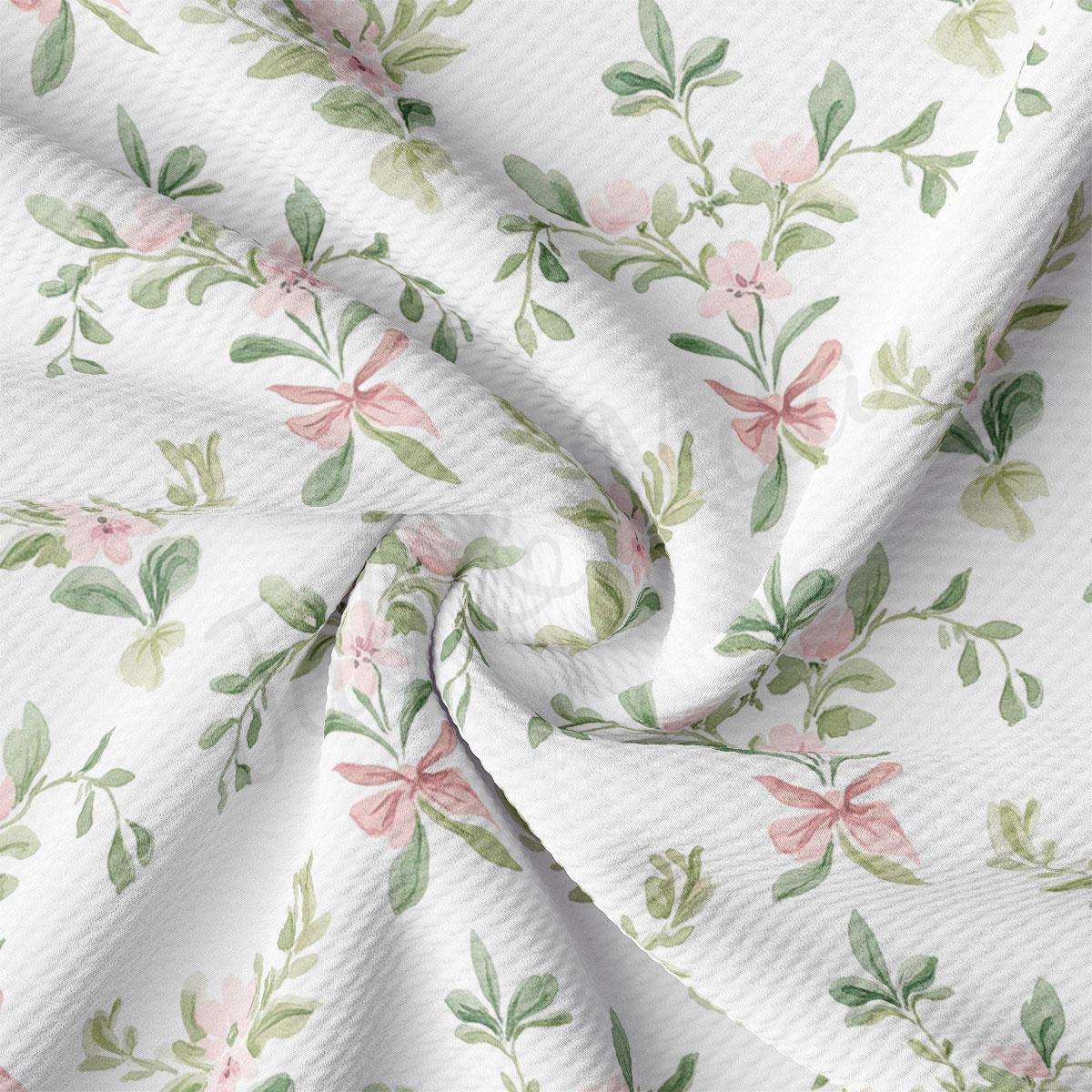 a close-up view of a fabric with a floral pattern. The fabric appears to be white and features a repeating pattern of pink flowers and green leaves. The pattern is intricate and detailed, creating a visually appealing design.