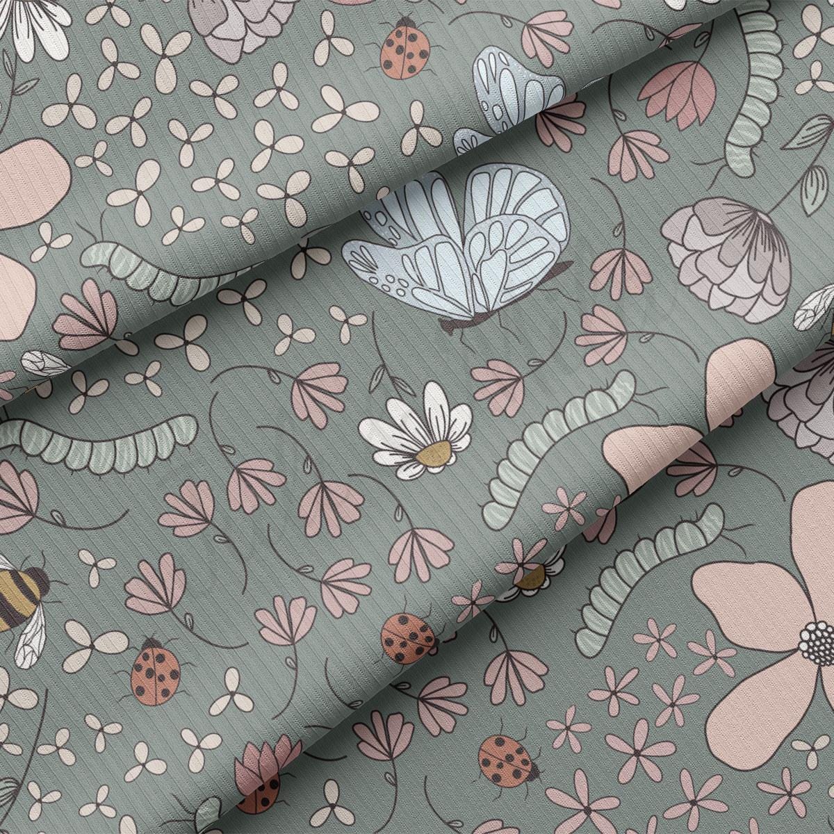 a close up of a fabric with flowers and bugs on it