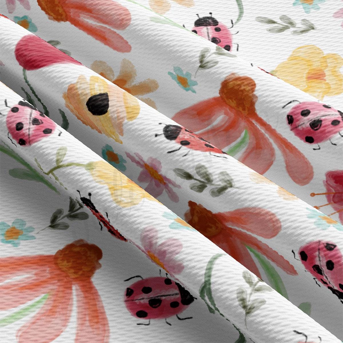 a close up of a pattern of flowers and ladybugs