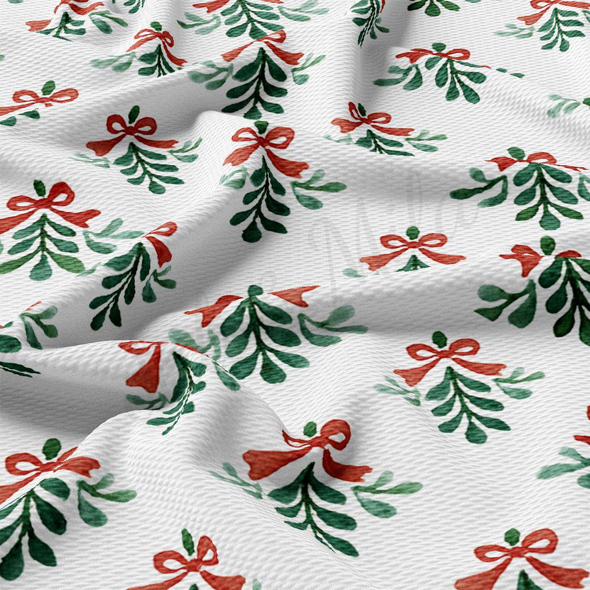 a close-up view of a fabric with a repeating pattern of green and red Christmas-themed designs, including mistletoe and bows.