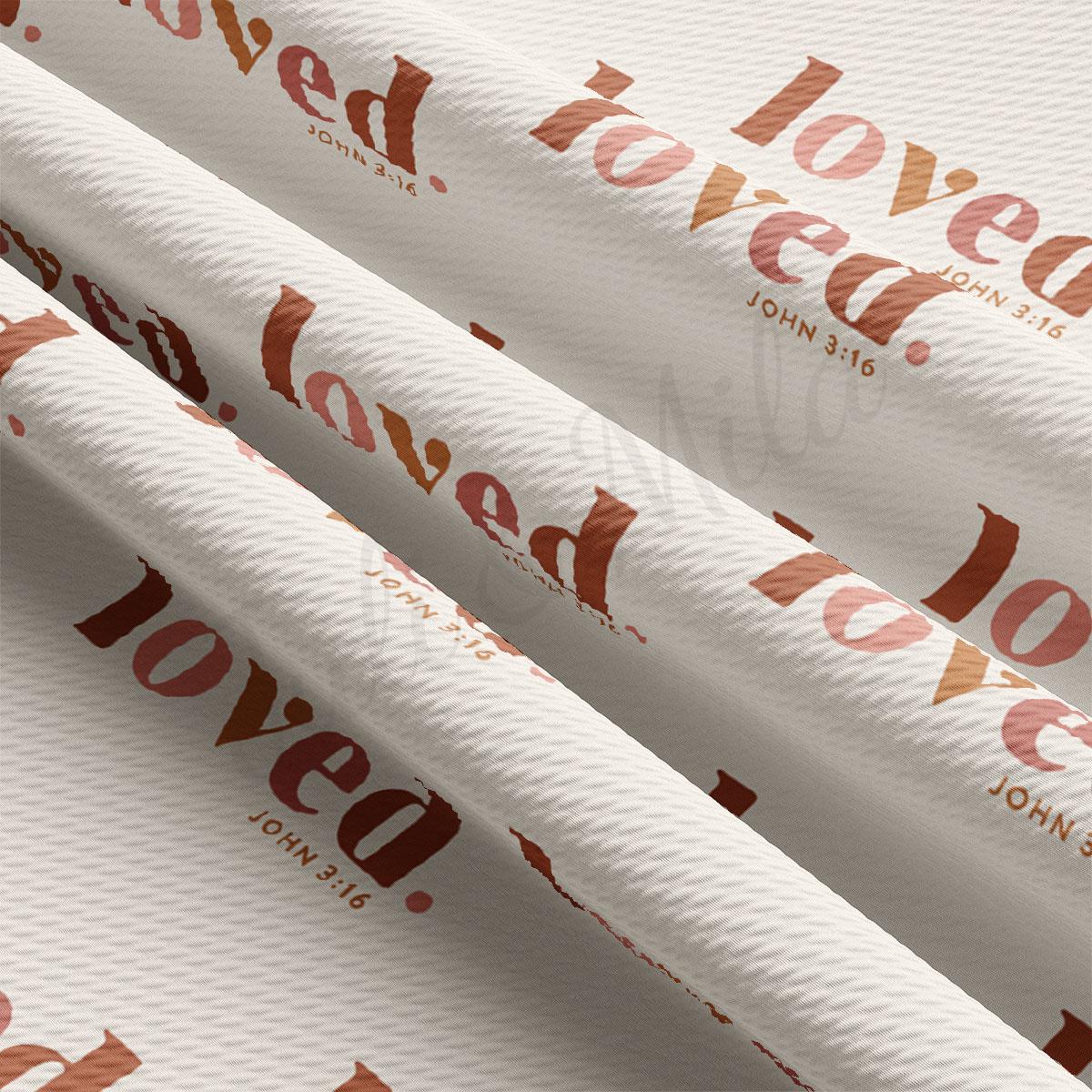 a close-up view of a fabric with a repeating pattern of the word "loved" in various shades of brown and orange. The pattern is printed on the fabric, creating a visually striking and textured appearance.