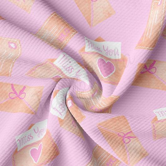 a pink fabric with a pattern of hearts and arrows