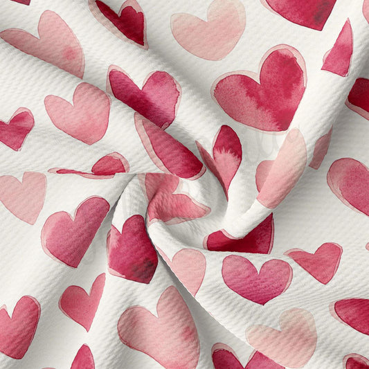 a close-up view of a fabric with a repeating pattern of pink hearts. The hearts are of various sizes and are arranged in a diagonal pattern across the fabric. The fabric appears to be wrinkled, giving it a textured appearance.