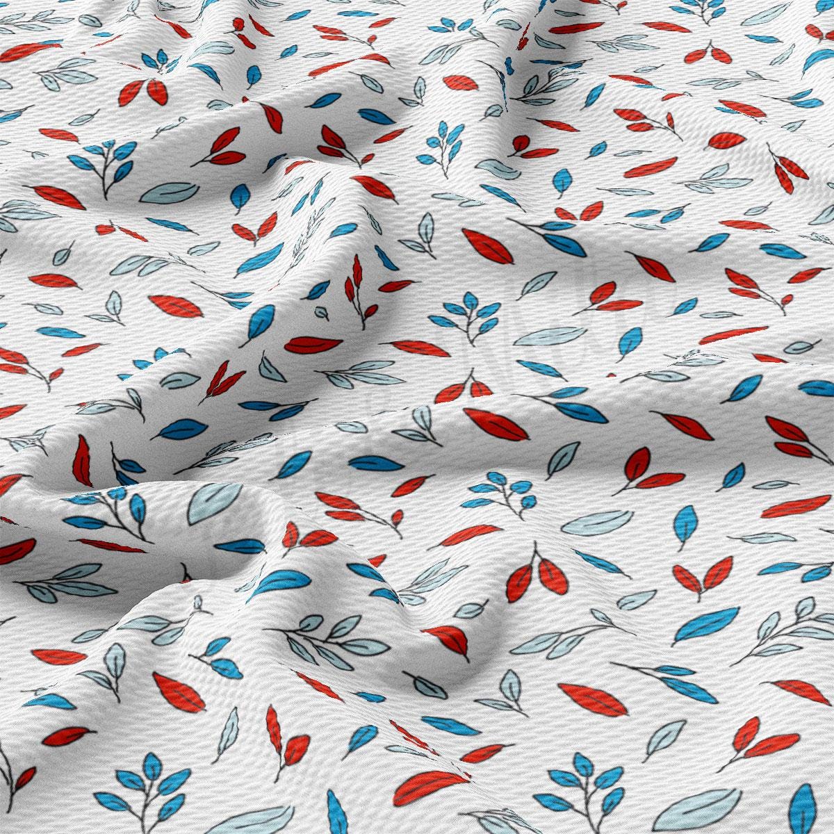 a close up of a white fabric with red, blue, and green leaves