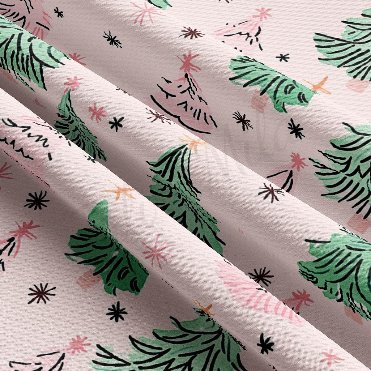a close-up view of a fabric with a repeating pattern of green Christmas trees and pink and white stars.