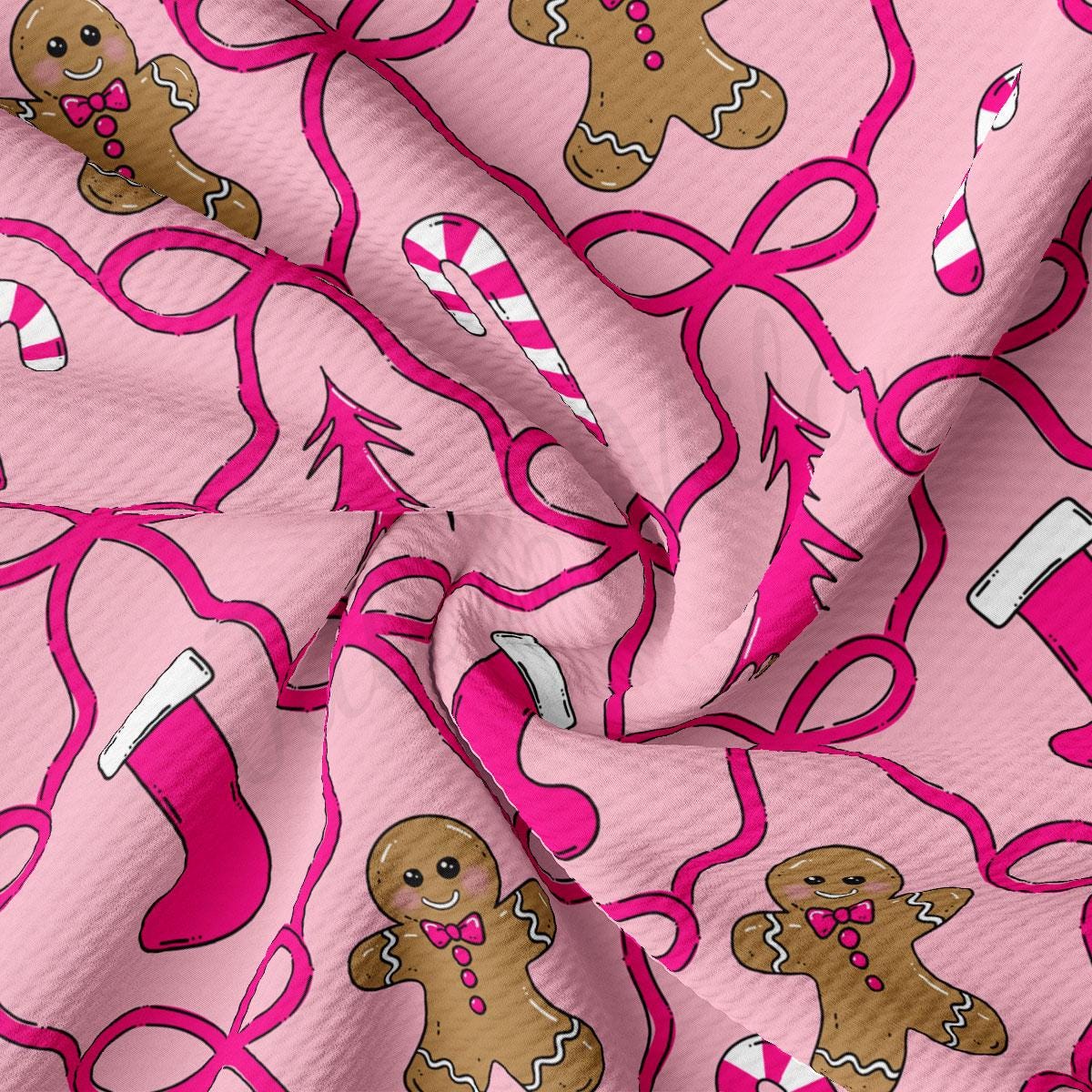 a close-up view of a fabric with a repeating pattern of gingerbread men and candy canes in shades of pink and white.