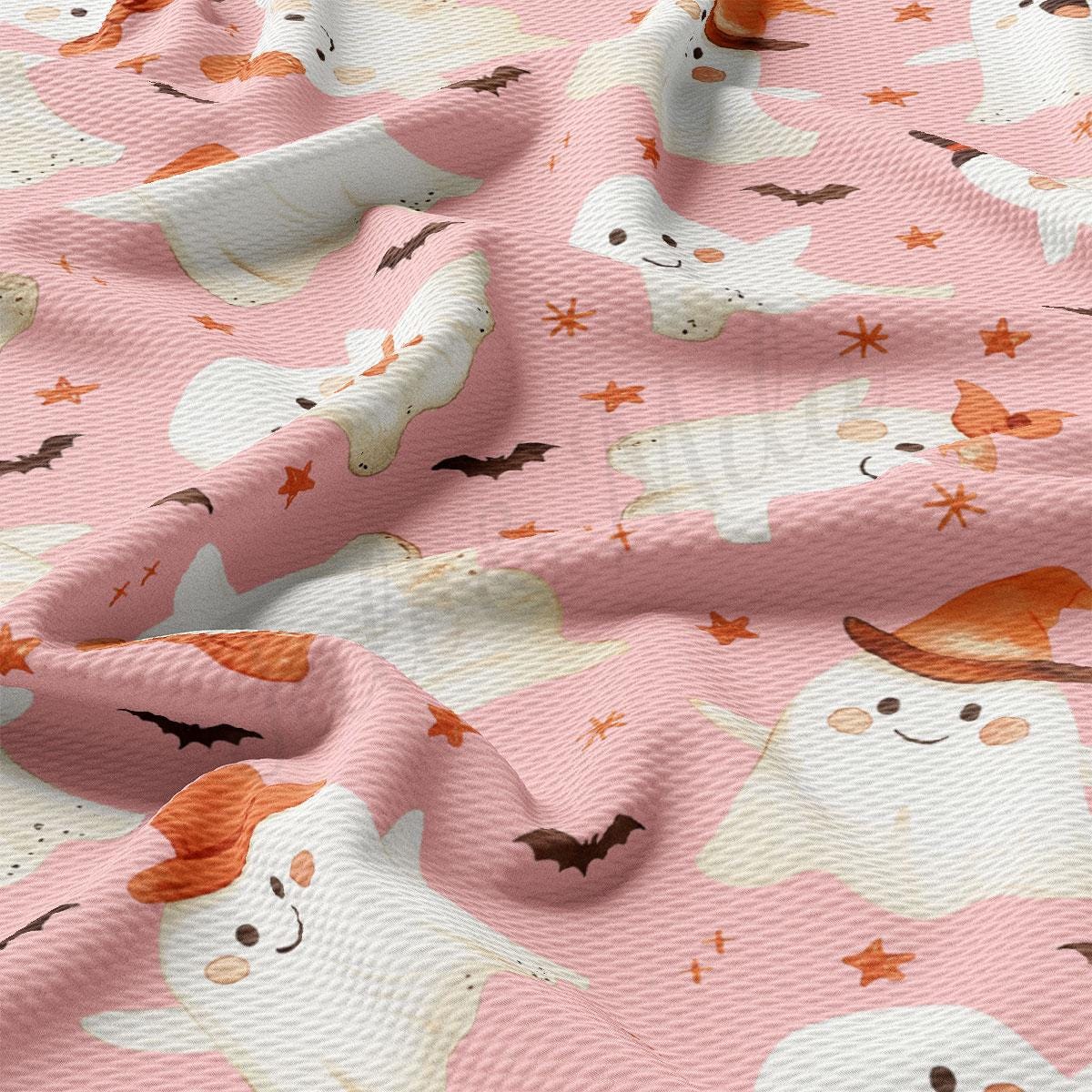 a pink fabric with a repeating pattern of ghost-like figures and bats, along with orange stars scattered throughout.