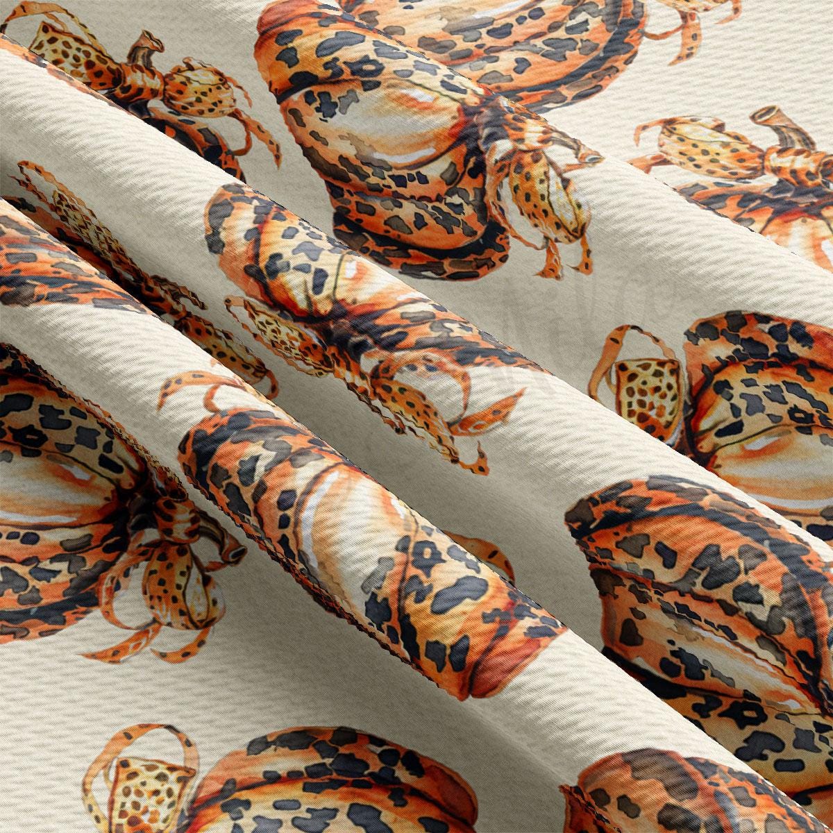 a close-up view of a fabric with a repeating pattern of leopard-like creatures, including snakes and lizards, printed on it.