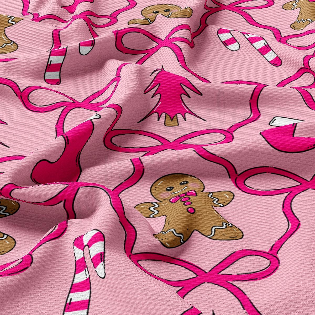 a close-up view of a pink fabric with a repeating pattern of pink ribbons and gingerbread man figures.