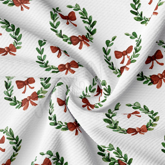 a close-up view of a fabric with a repeating pattern of green leaves and red bows.