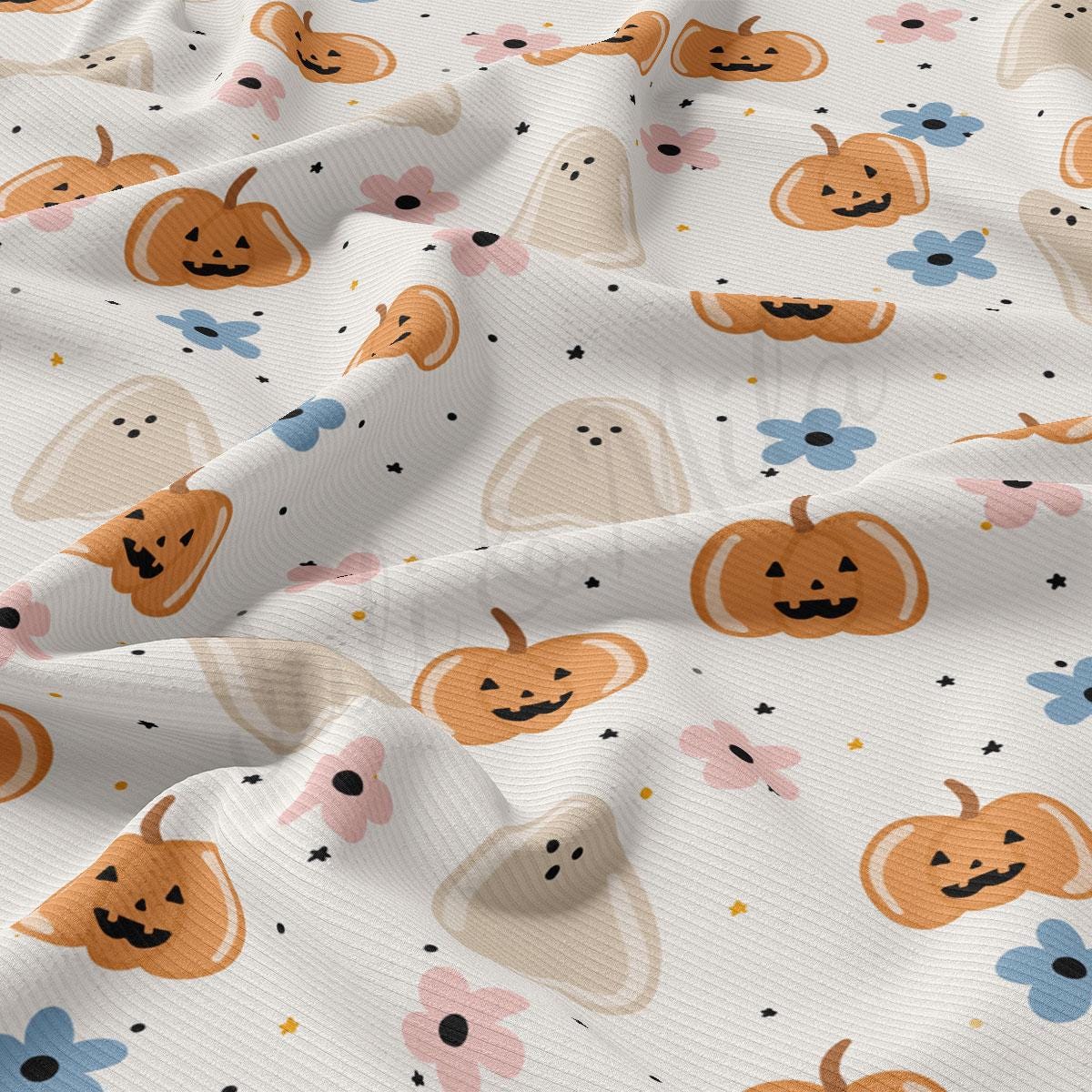 a close-up view of a fabric with a repeating pattern of Halloween-themed pumpkins and ghost shapes.