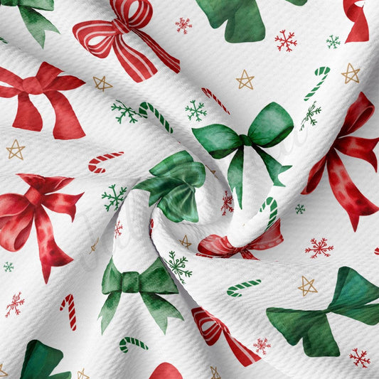 The image is a close-up of a fabric with a repeating pattern of Christmas-themed elements, including red and green bows, candy canes, snowflakes, and stars.