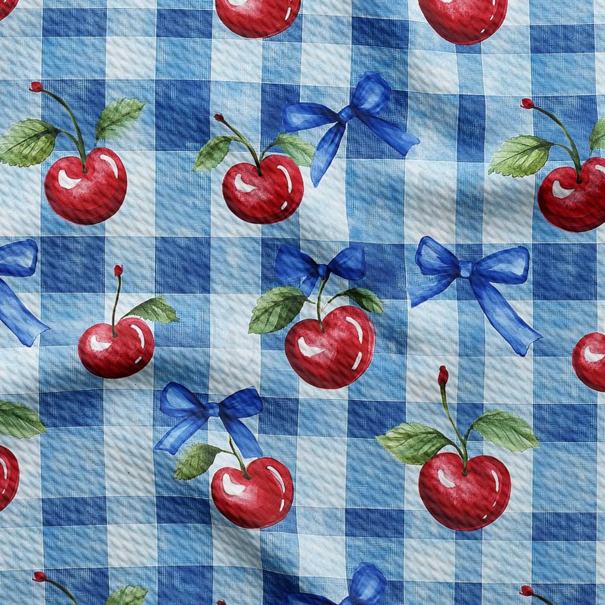a blue and white checkered fabric with cherries on it