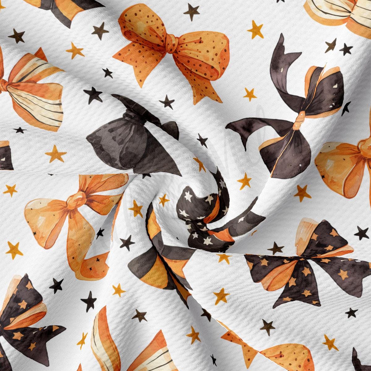 a close-up view of a fabric with a repeating pattern of orange and black bows, along with scattered stars and black silhouettes.