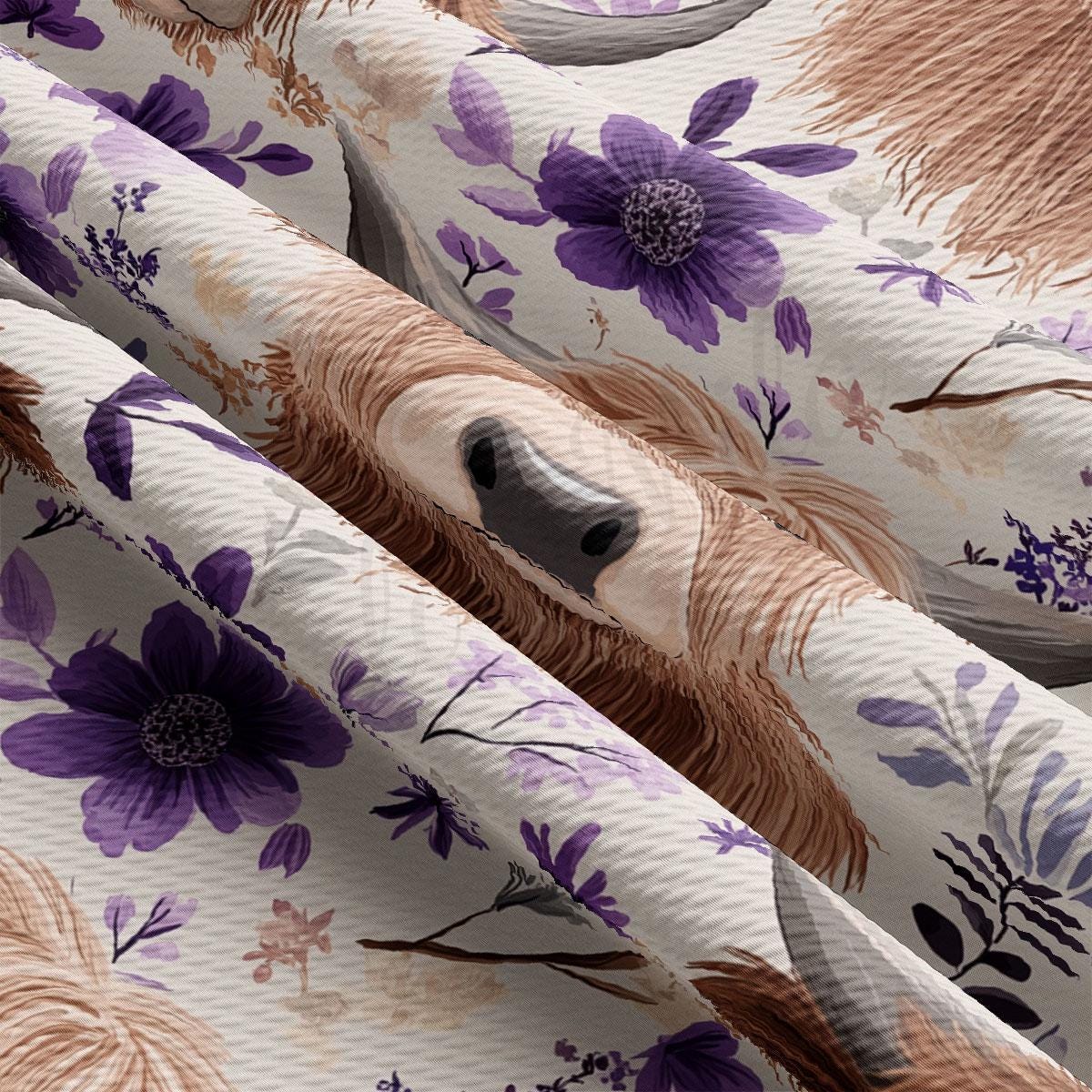 a close-up view of a fabric with a floral pattern, including purple flowers and leaves. The fabric appears to be made of a soft, textured material, possibly cotton or linen. The pattern is intricate and detailed, with the flowers and leaves overlapping and creating a visually appealing design.