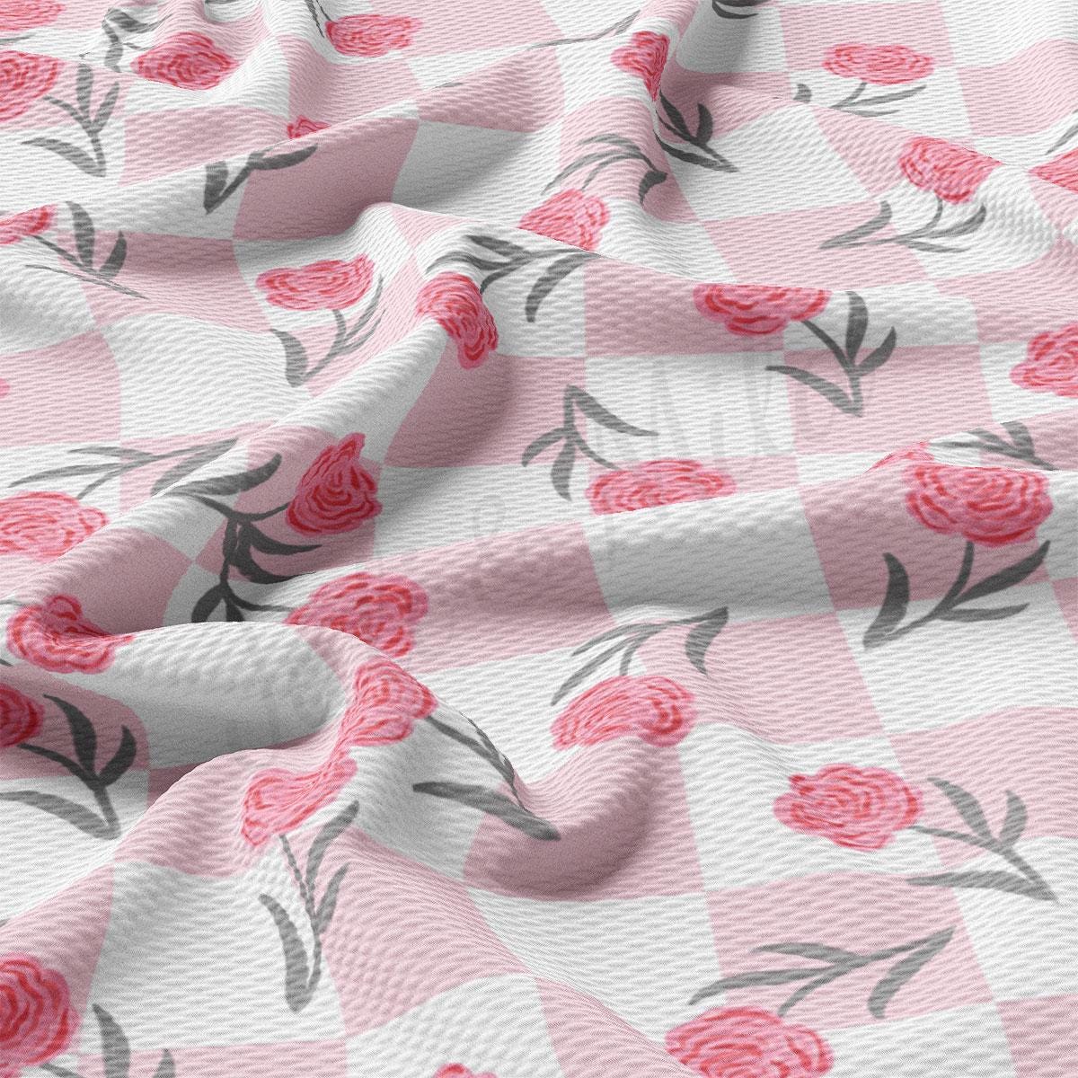 a pink and white checkered fabric with roses on it