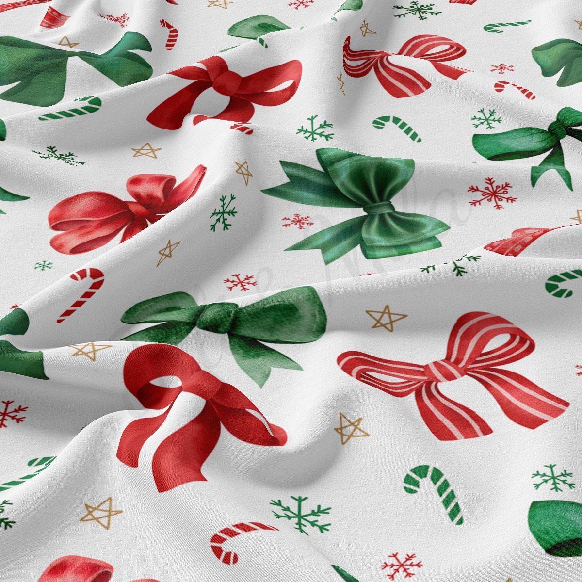 a white fabric with a repeating pattern of red and green bows, stars, and snowflakes.