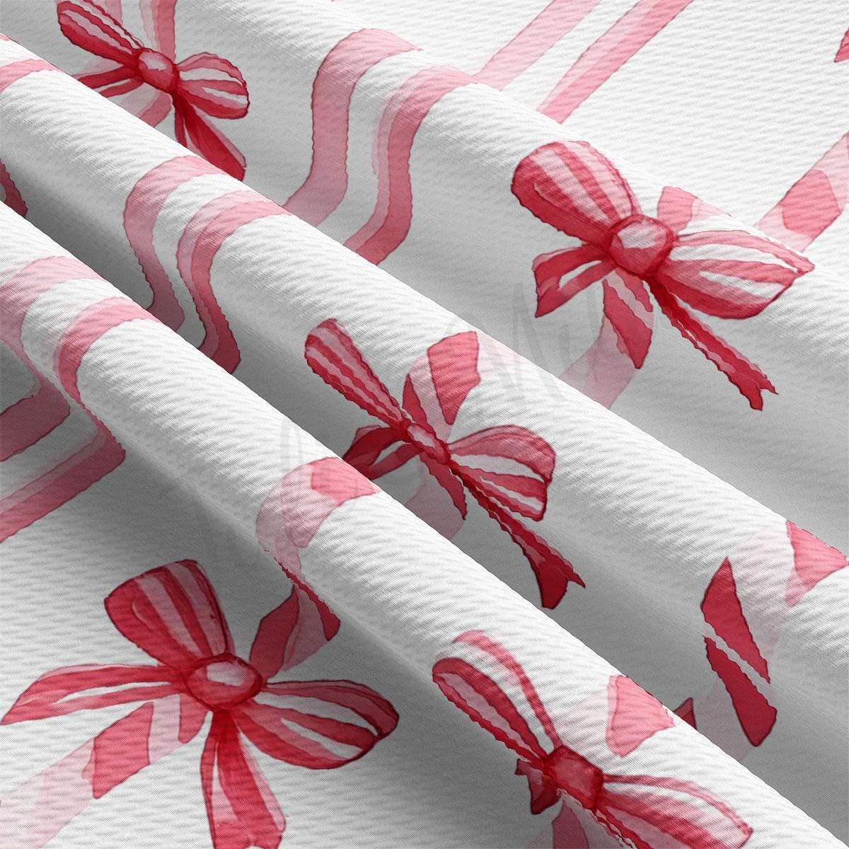 a close-up view of a fabric with a repeating pattern of red bows on a white background.