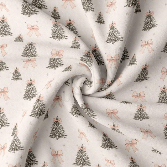 a close-up view of a fabric with a repeating pattern of Christmas trees and pink bows.