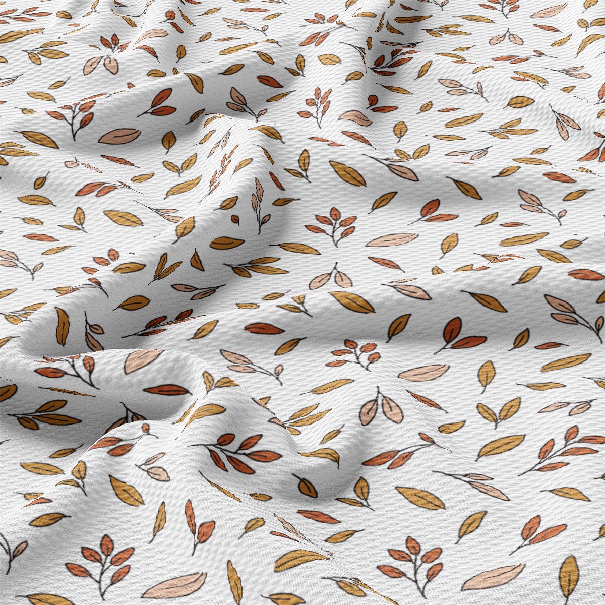 a close up of a white fabric with leaves on it