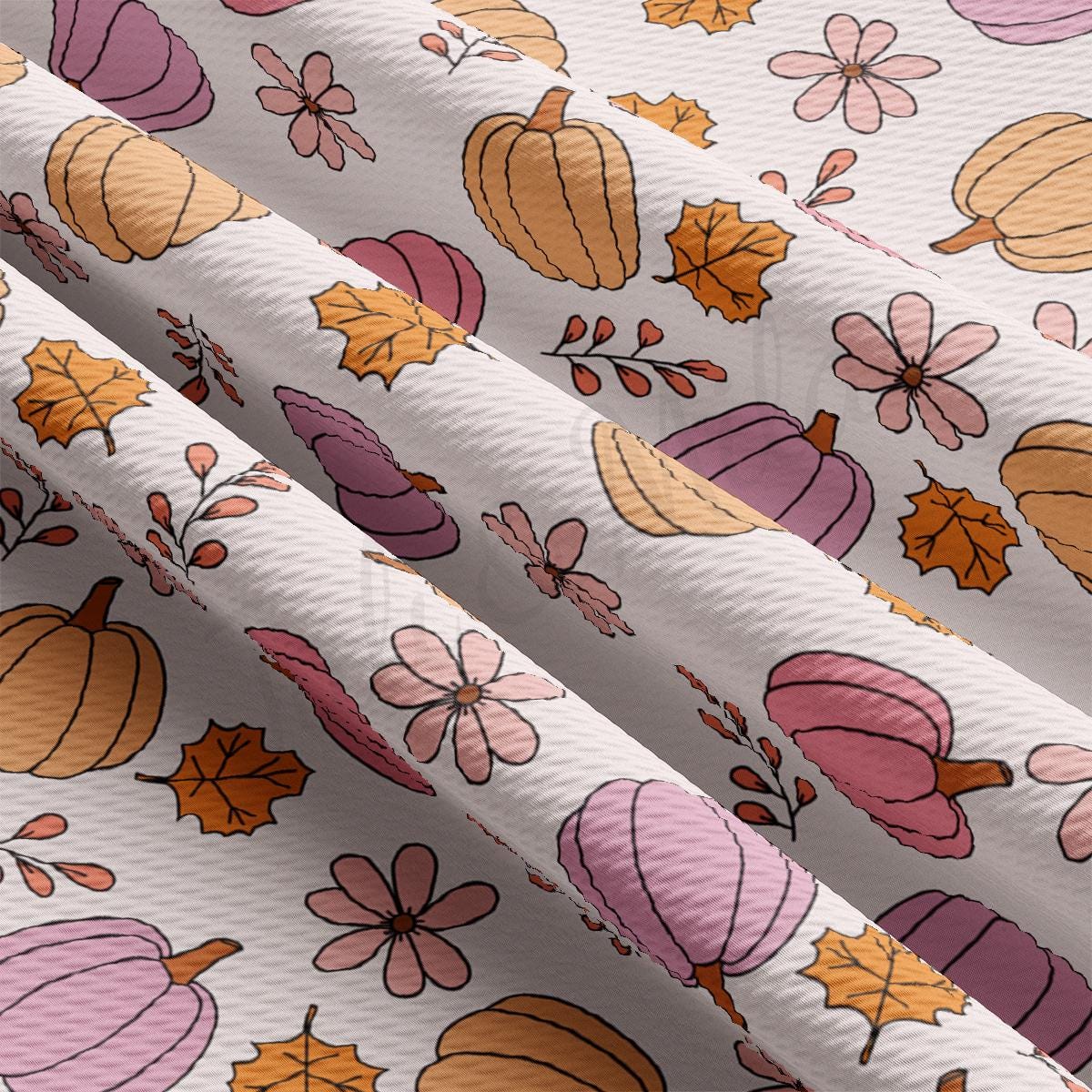 a close up of a white fabric with a pattern of pumpkins and leaves