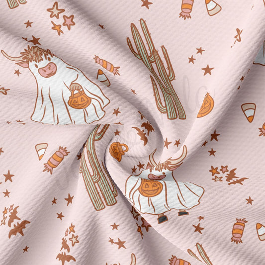 a pink fabric with a cow and cactus on it