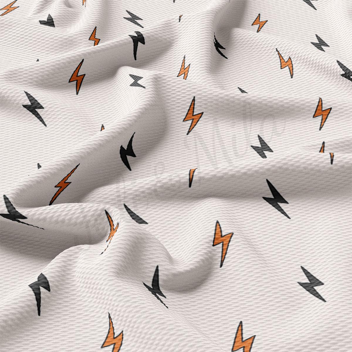 a white fabric with orange and black lightnings on it