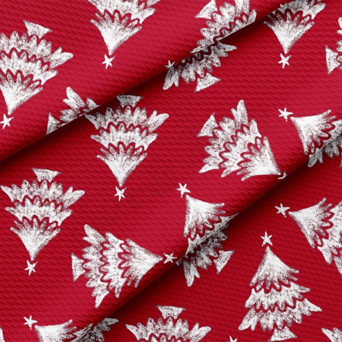 a red fabric with white christmas trees on it