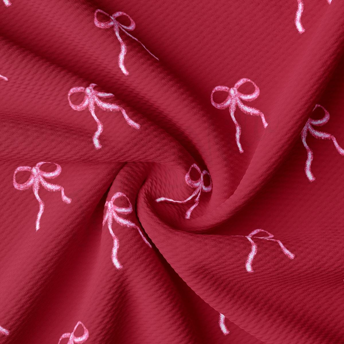 a close up of a red fabric with pink bows on it