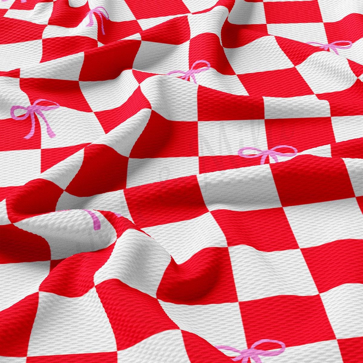 a red and white checkered fabric with a pink ribbon