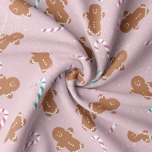 a close up of a pink fabric with gingerbreads on it