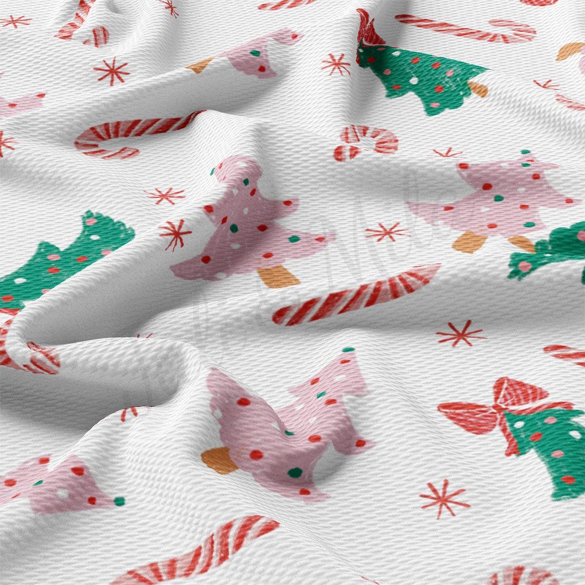 a close up of a white fabric with christmas trees and candy canes
