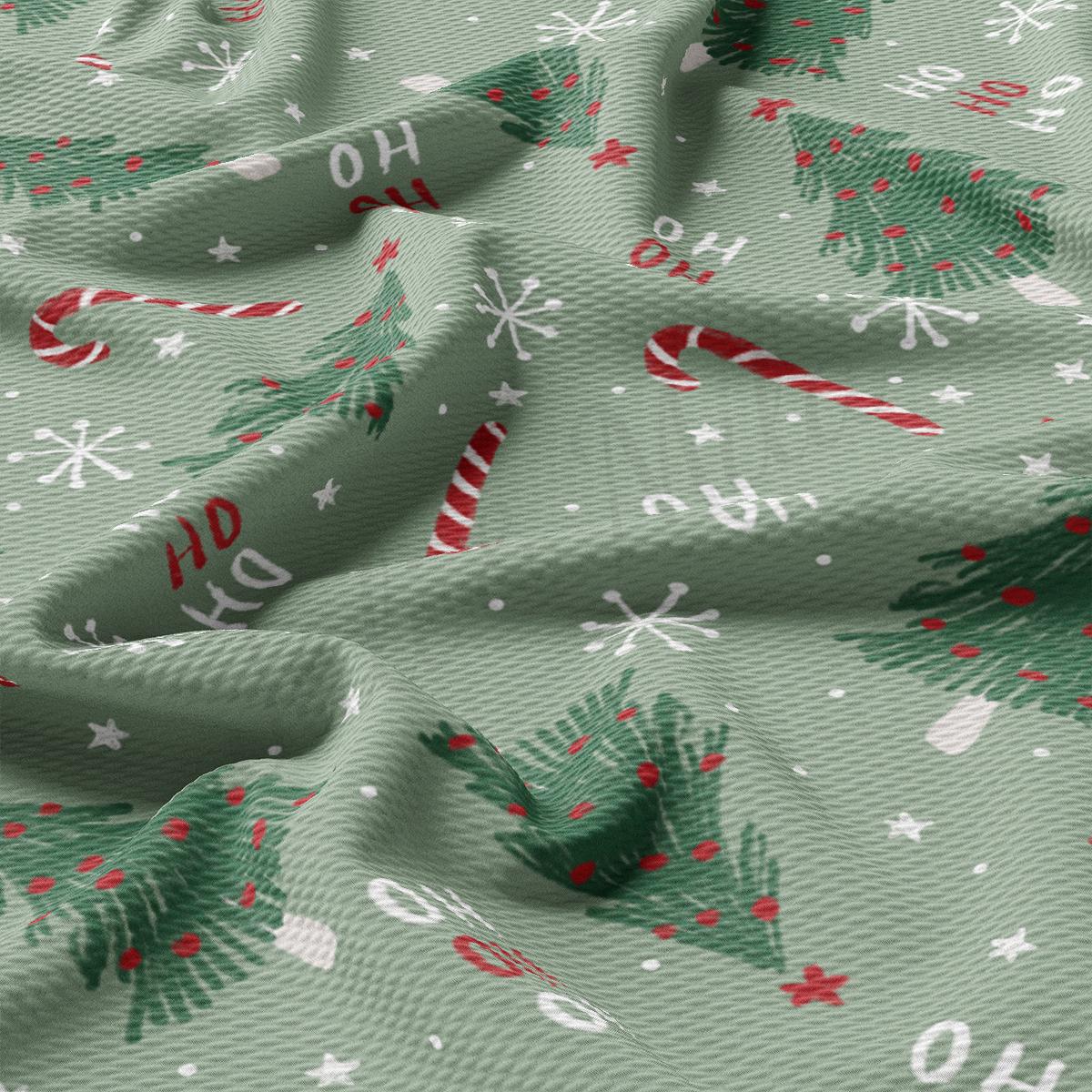 a green fabric with christmas trees and candy canes