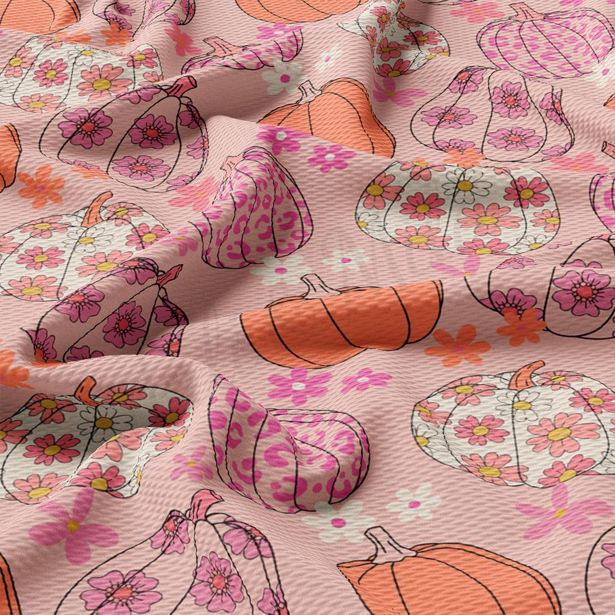 a pink and orange fabric with pumpkins on it